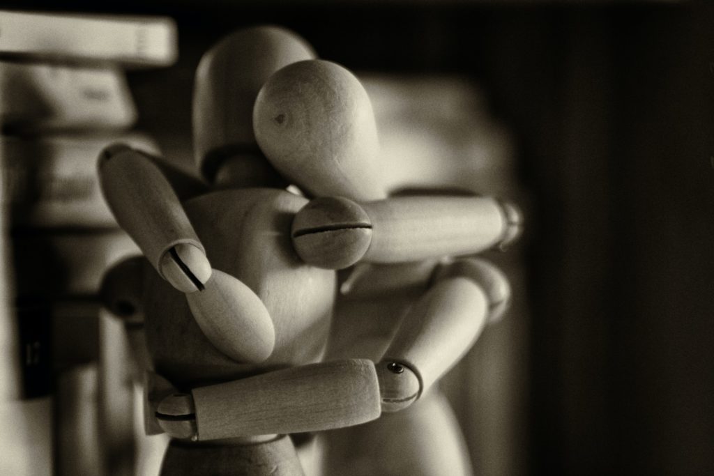 Dwie przytulajace się drewniane figurki